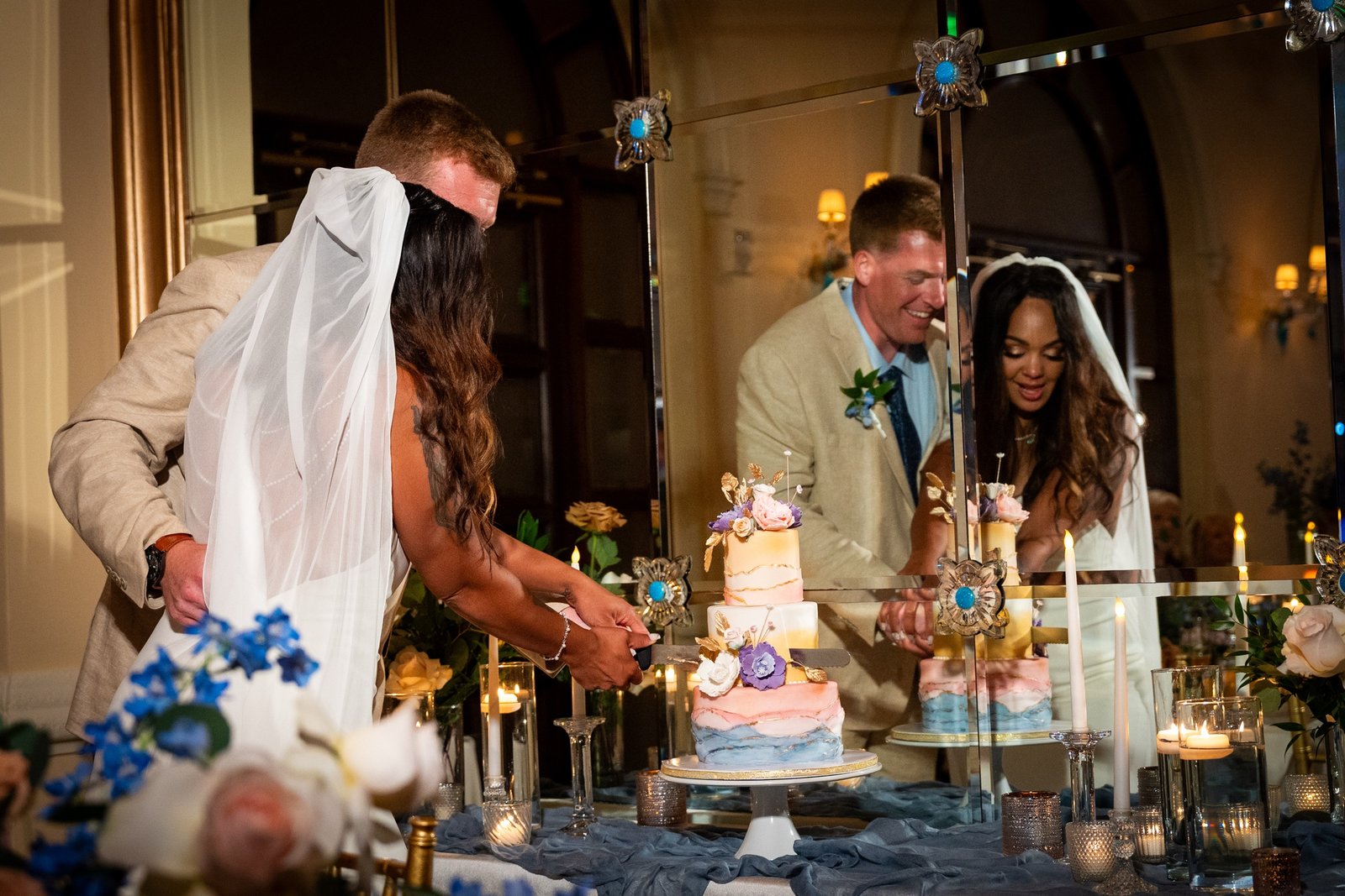 Cake cutting reflected in the reception's mirrored wall